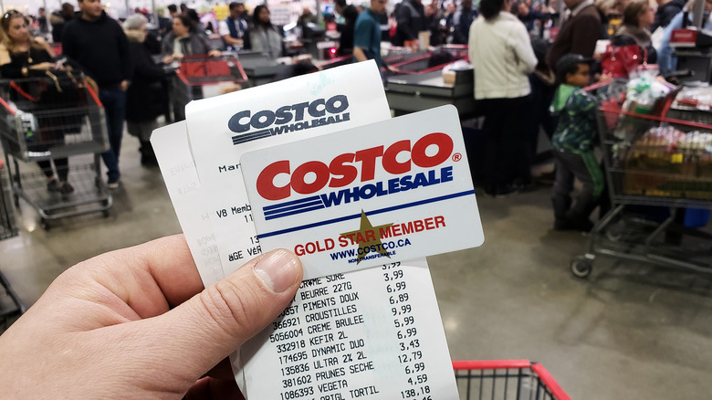 white hand holding Costco card