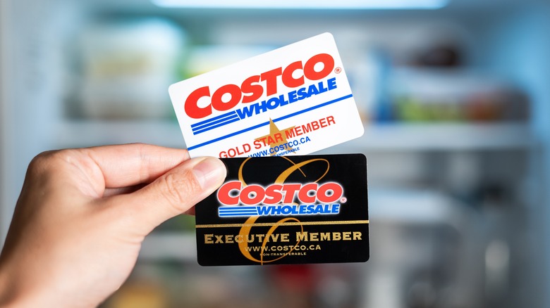 Person holding Costco Wholesale membership cards