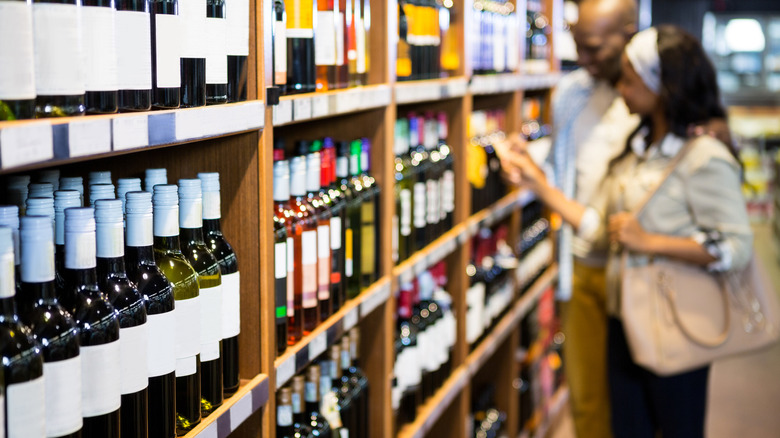 couple buying wine at grocery store