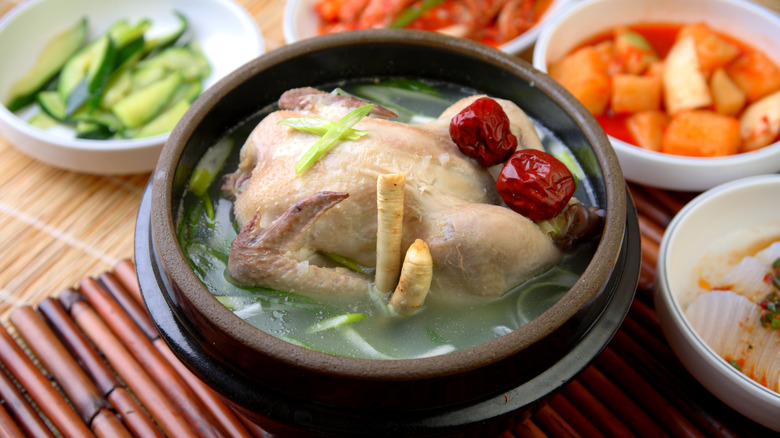 Whole chicken in a pot of soup.