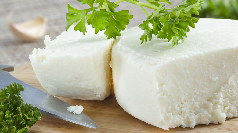 Wedges of cotija with fresh cilantro on a cutting board