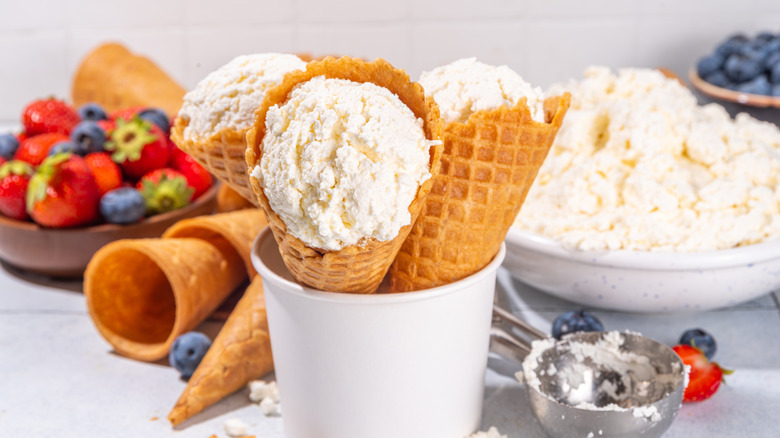 waffle cones filled with vanilla cottage cheese in a white paper cup in front of other ice cream ingredients