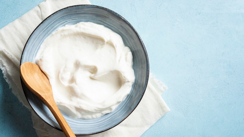 Bowl of cream cheese with a wooden spoon in it