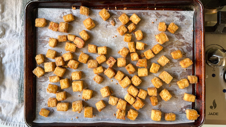 Crispy baked sesame tofu cubes on sheet pan