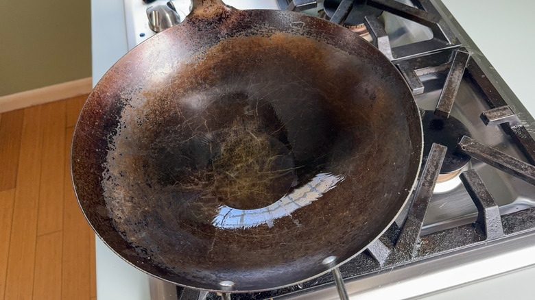 Wok with avocado oil heating on stovetop