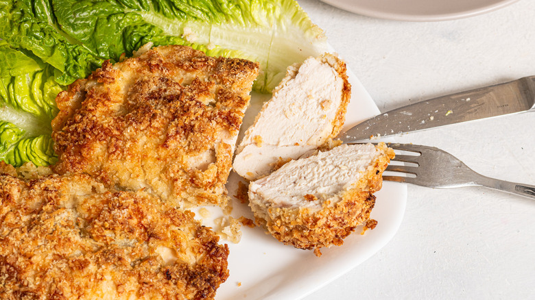 Crispy coconut baked chicken breasts with one sliced