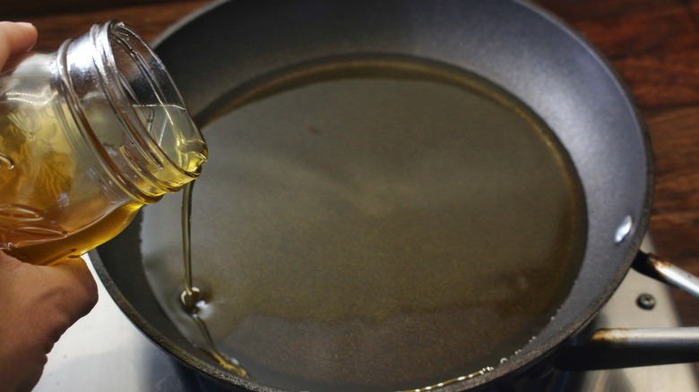 pouring oil into skillet