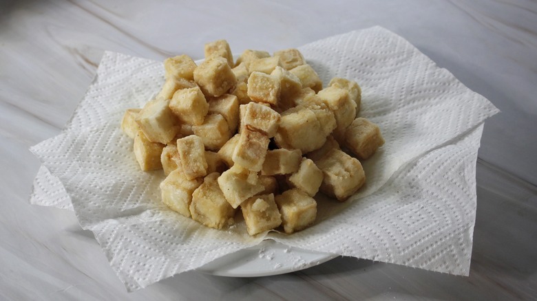 fried tofu on plate with paper towels