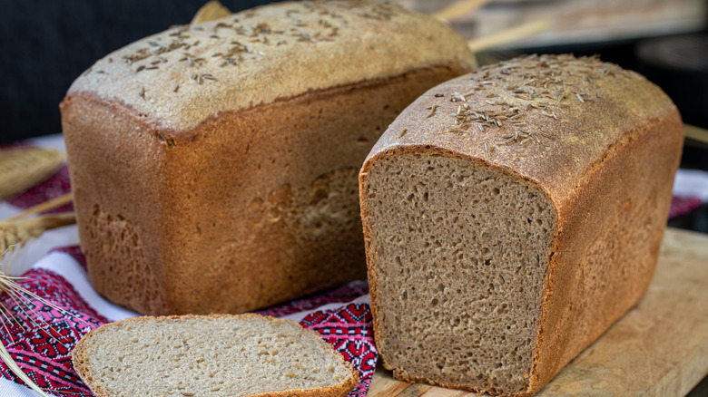 Sliced loaf of rye bread topped with caraway seeds