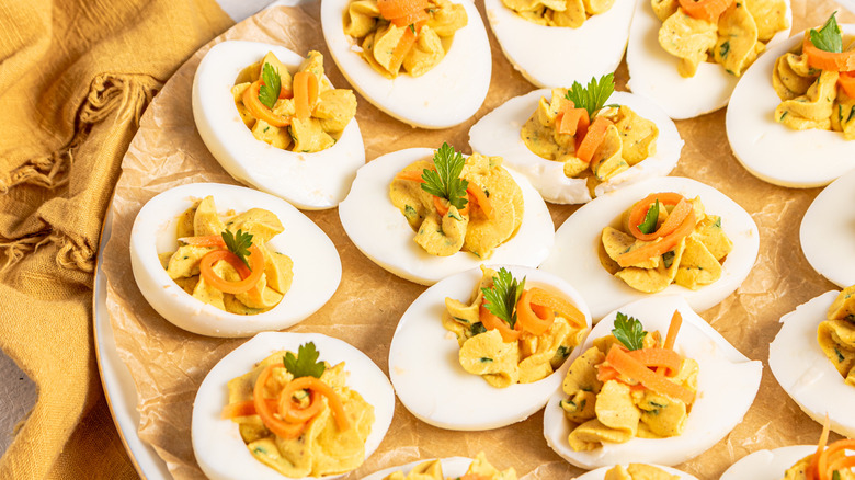 Curried deviled eggs With pickled carrots on a plate