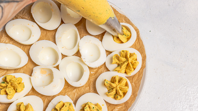 Piping egg yolk mixture into egg whites