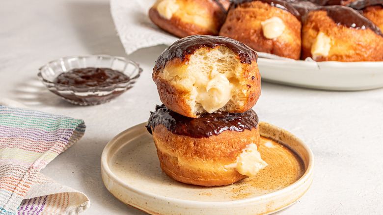 Two custard-filled Boston cream donuts one on top of each other