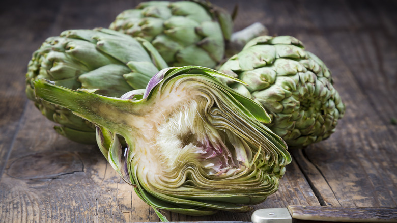 Artichokes cut in half on a wooden table