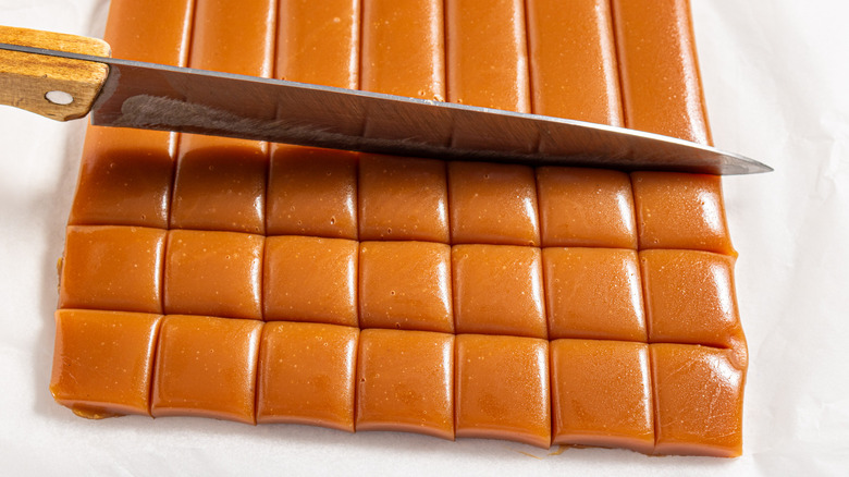Knife cutting caramel into squares