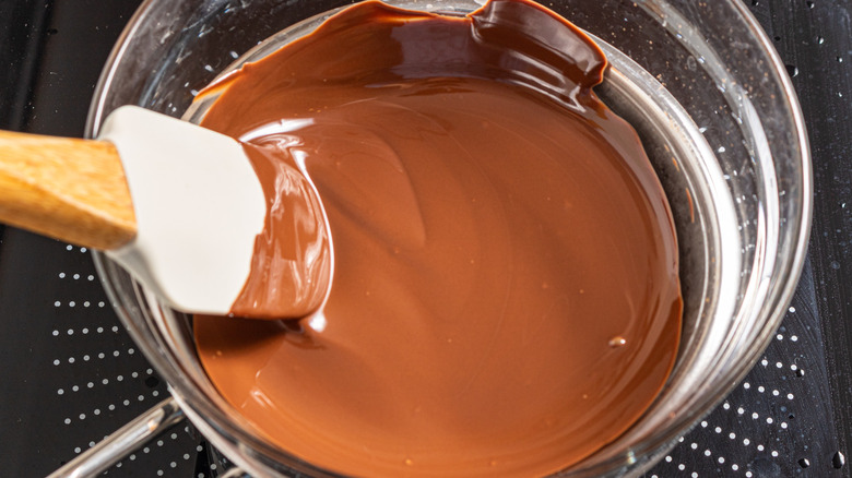 Spatula in bowl with melted chocolate