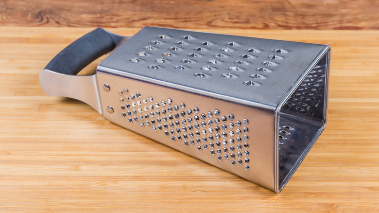 Box grater on a wooden cutting board