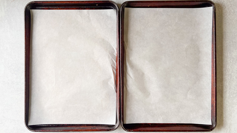 Two half sheet pans lined with parchment paper
