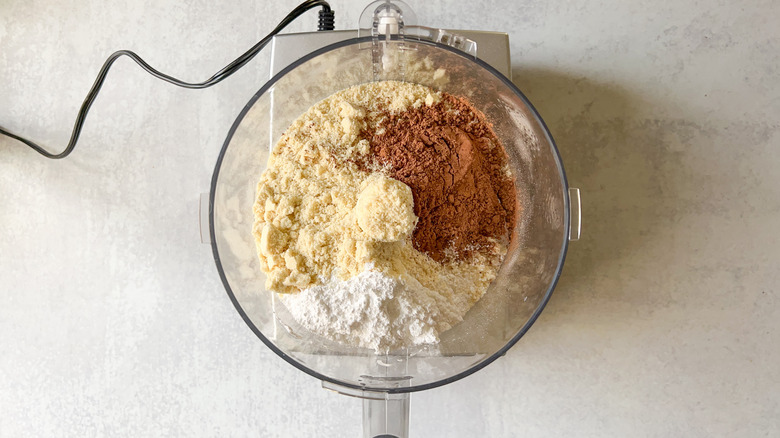 Dry ingredients for chocolate macarons in food processor bowl