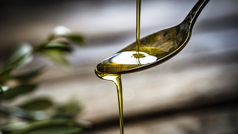 Olive oil poured into spoon