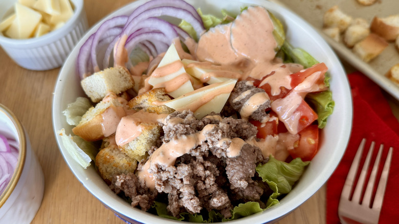 cheeseburger bowl with various toppings and sauce