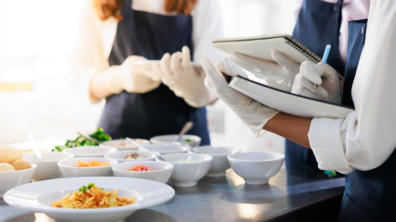 Culinary Students Take Notes In Kitchen