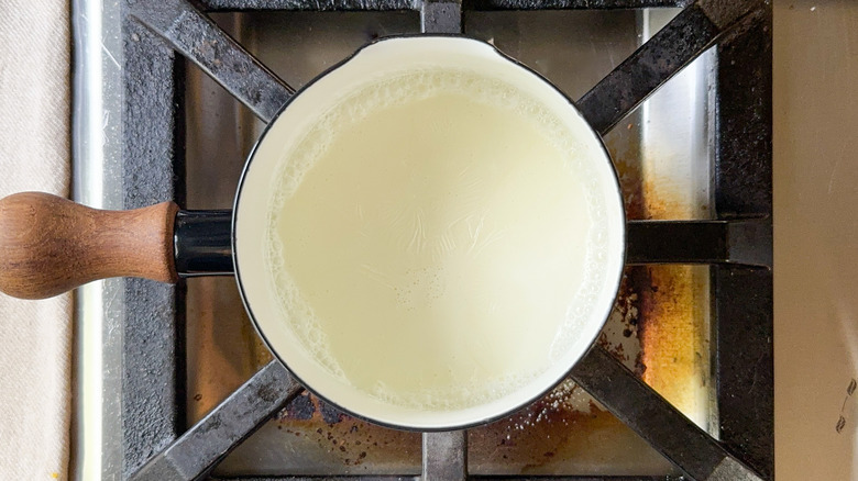 Heavy cream simmering in pot on stove