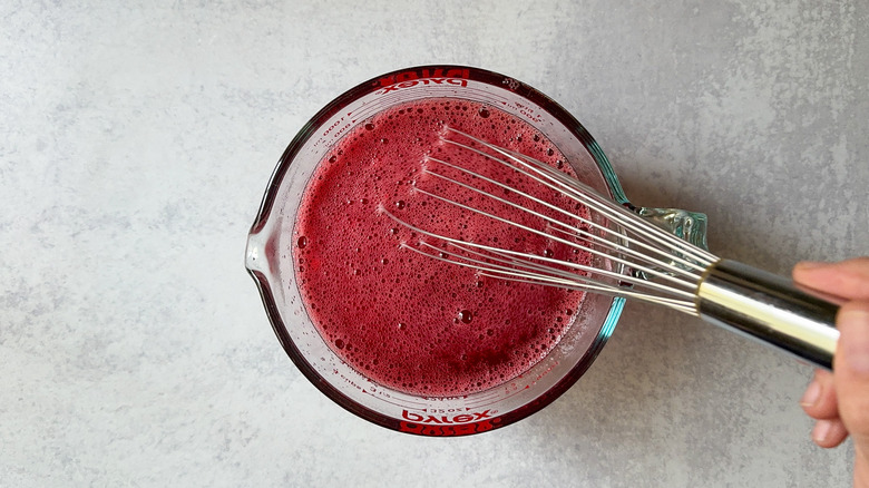 Whisking raspberry jello in measuring pitcher