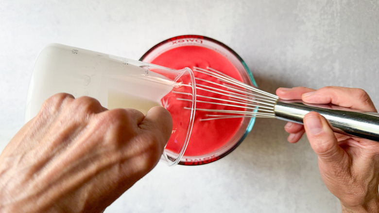 cream pouring into red mixture