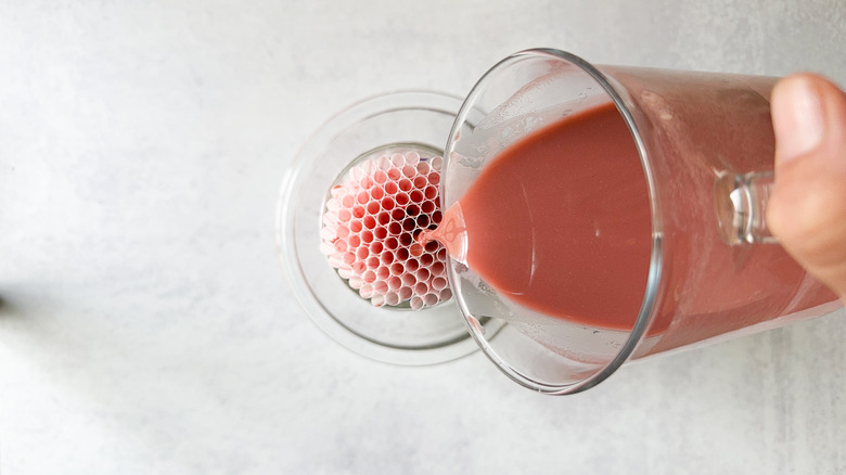 Pouring red liquid into straws