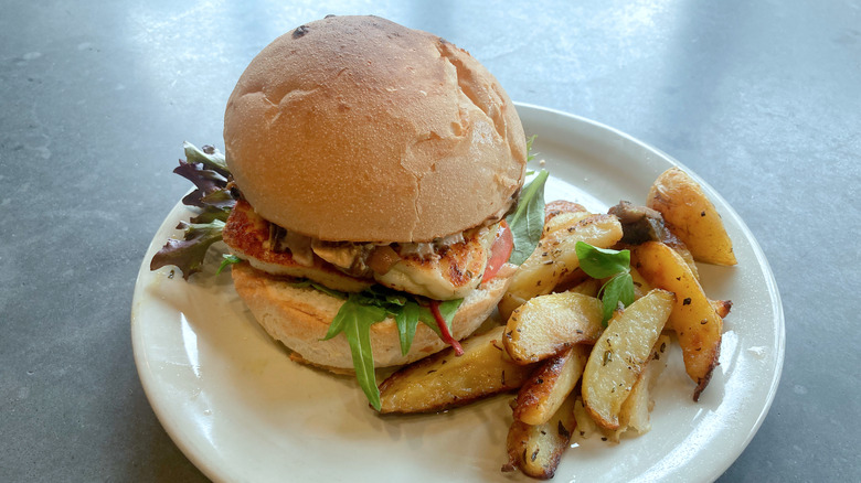 Grilled halloumi slider on a plate with potato wedges