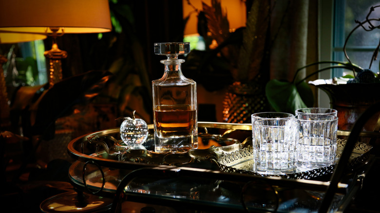 An elegant bar cart in a cozy, dimly lit den.