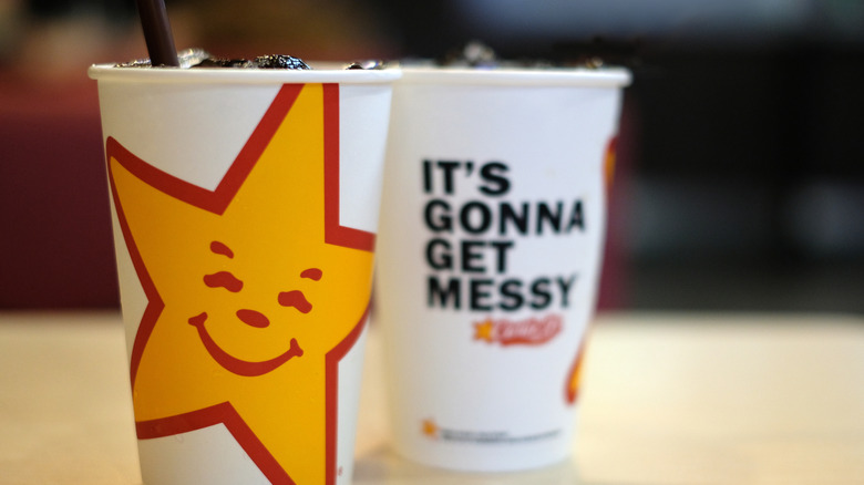 Two Carl's Jr. soda cups on white table