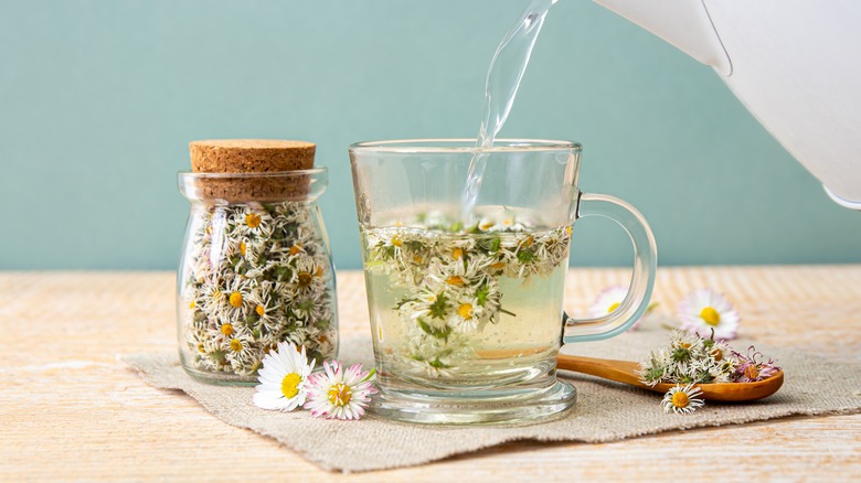 Hot water pouring into loose leaf tea from electric kettle