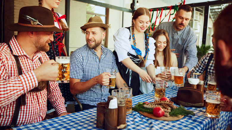 People drinking at a table at Oktoberfest.