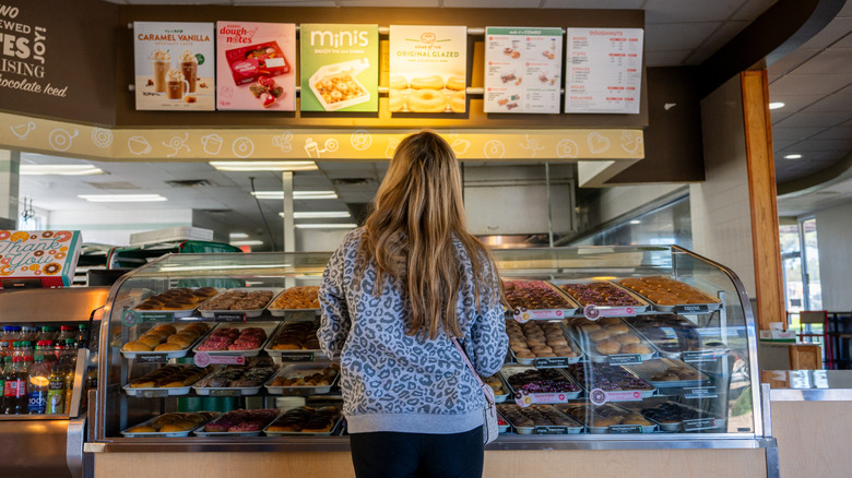 woman standing in front of Krispy Kreme donuts