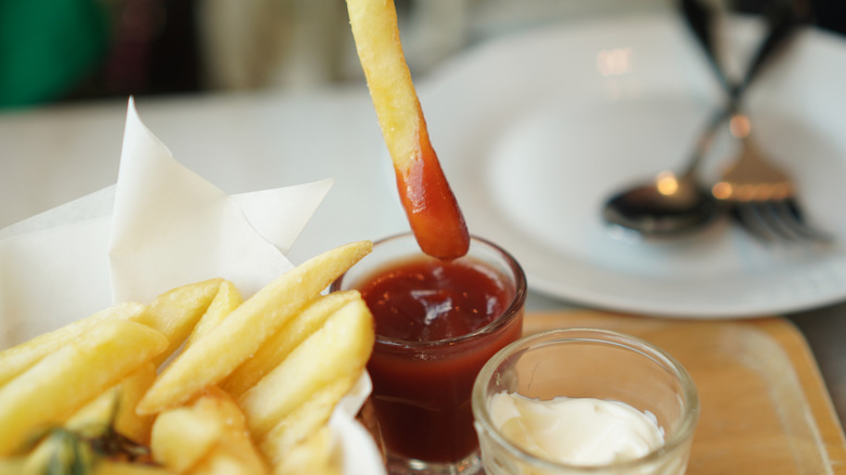 Dipping a French fry into ketchup