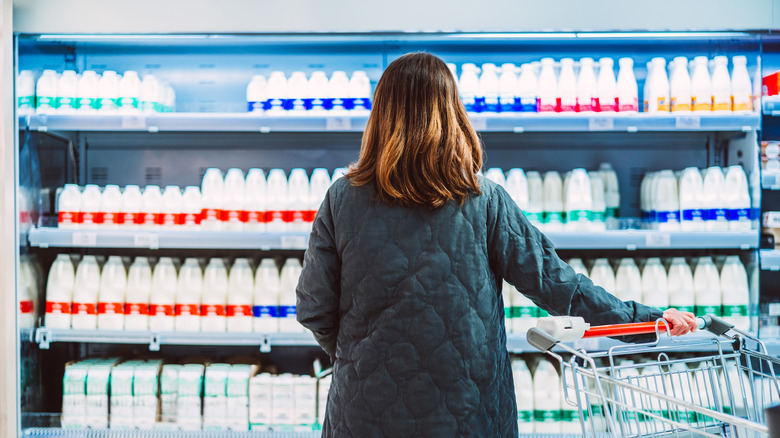 Woman looking at milk aisle in grocery store