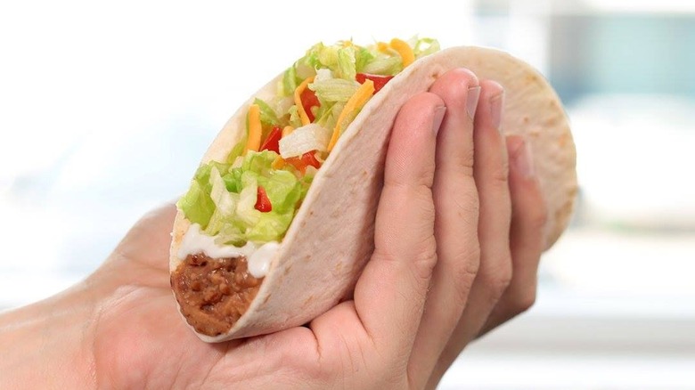 Person holding Taco Bell's Soft Taco Supreme