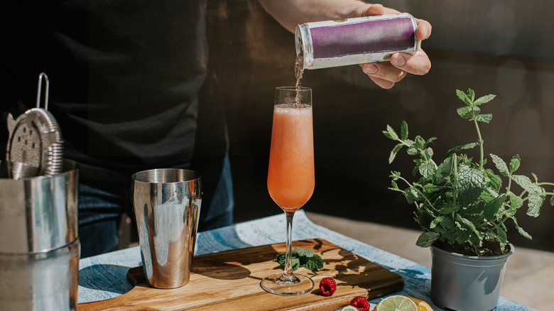 Bartender pouring a can of juice into a glass