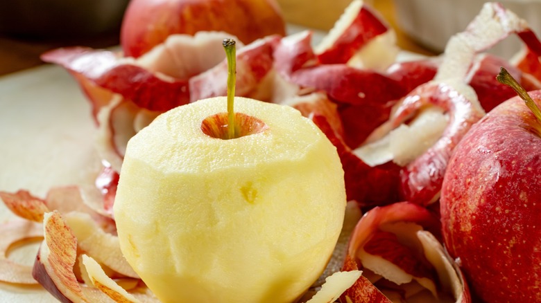 peeled apple surrounded by peels