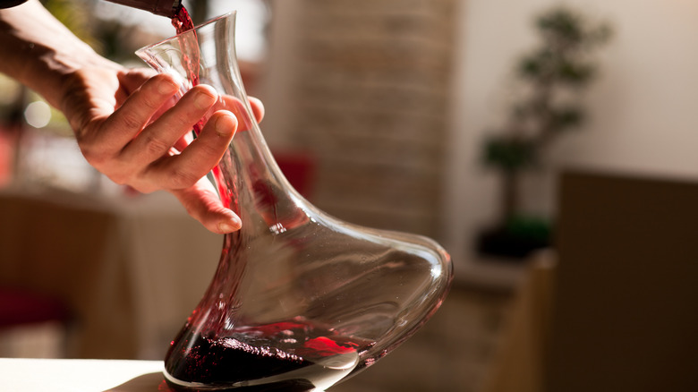 Filling a glass decanter with red wine