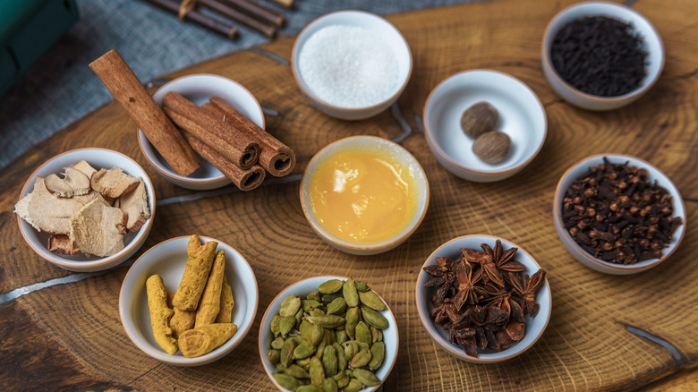 Assortment of chai spices on small white plates