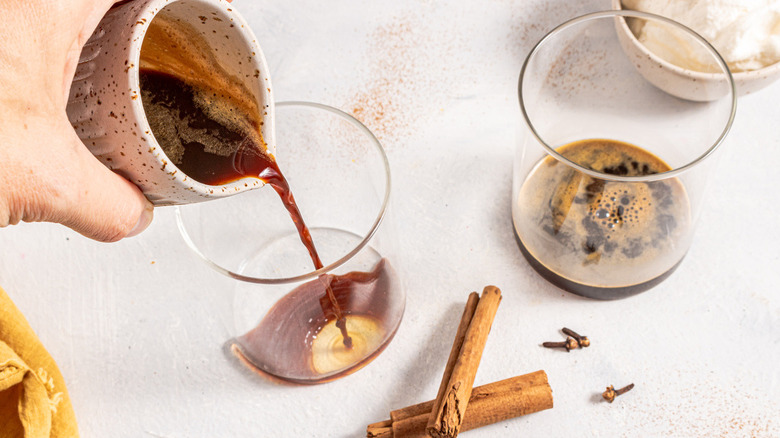 hand pouring coffee into glass