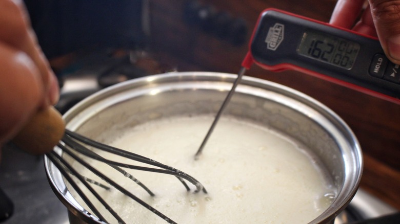 measuring pudding temperature in pot with thermometer