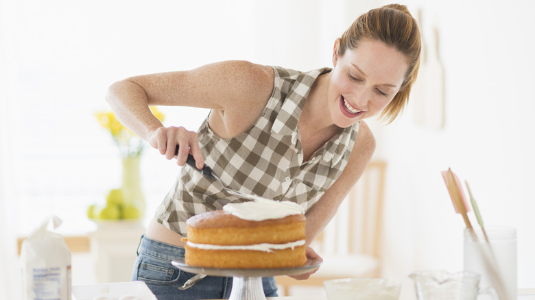 Woman frosting a layer cake