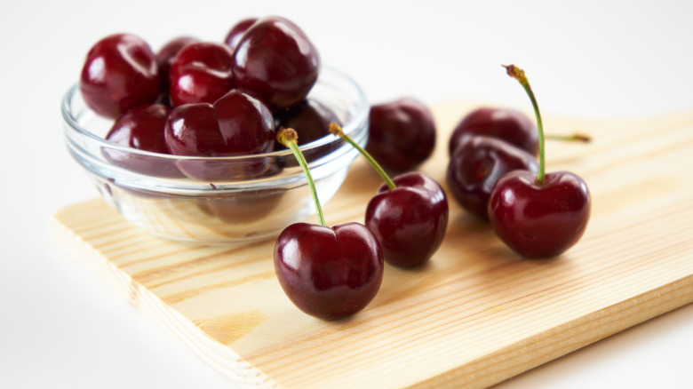 Cherries in bowl and on wooden plank