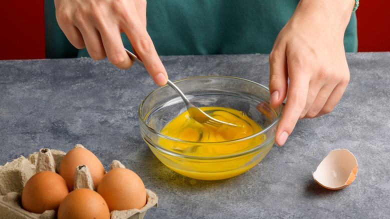 Person whisking eggs in bowl