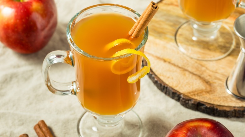 A glass mug of spiked hot apple cider