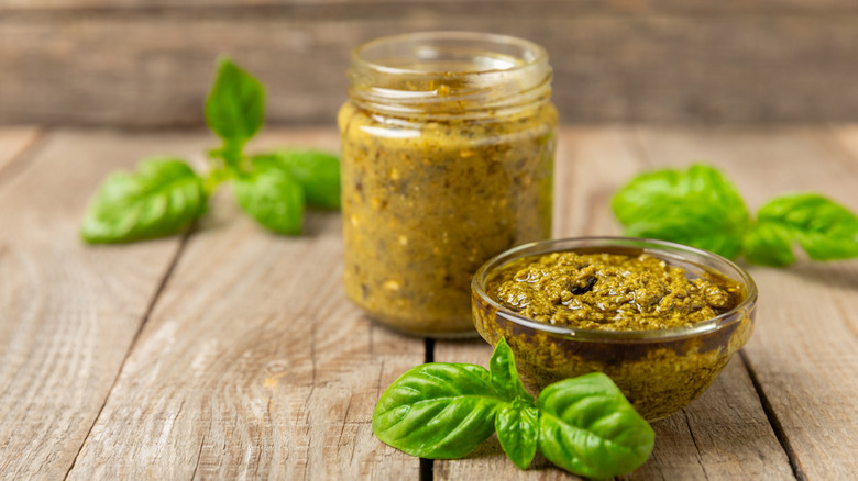 Jar of pesto with fresh basil leaves