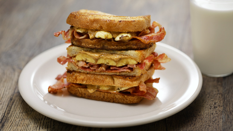 stack of peanut butter, banana, and bacon sandwiches on white plate